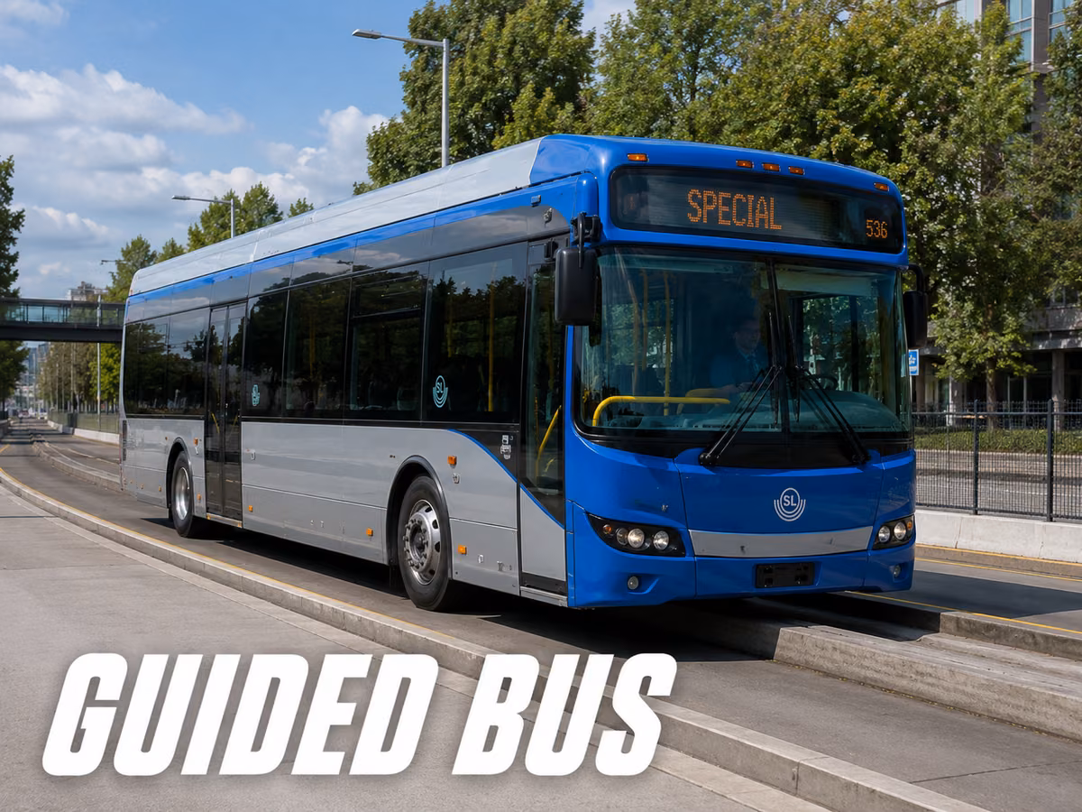 Blue and silver guided bus running on a dedicated concrete guideway with raised curbs