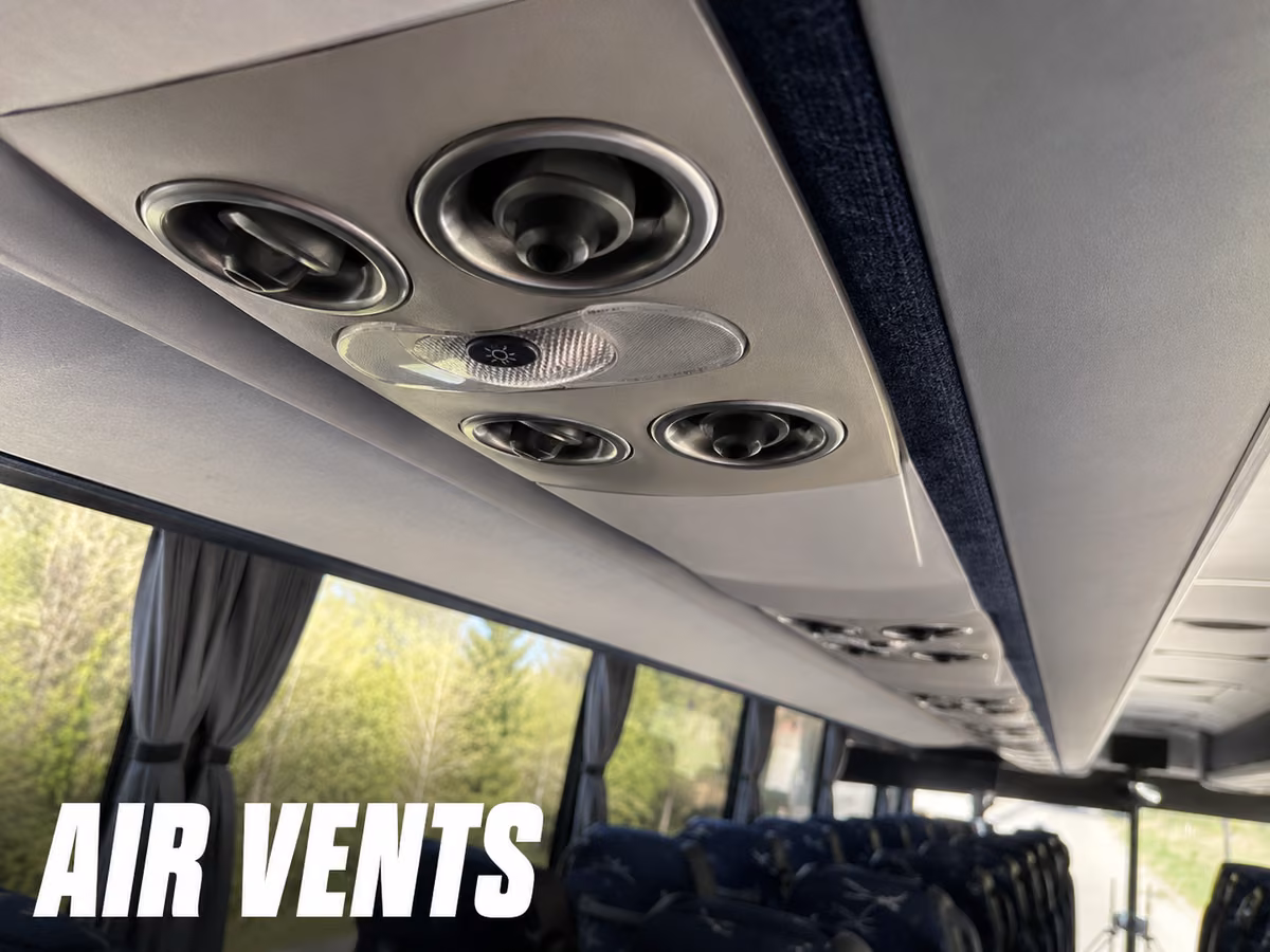 Overhead air vents and reading lights above charter bus seats