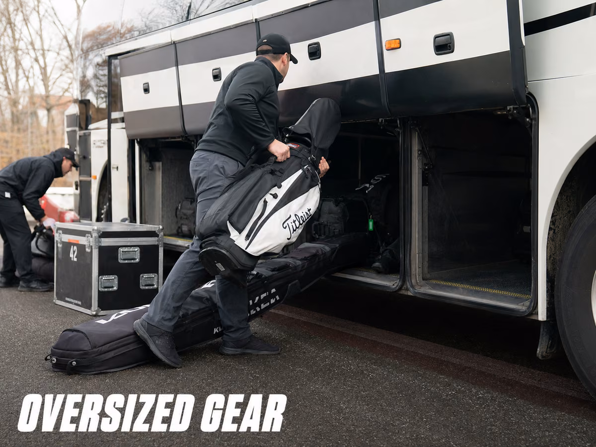 Oversized bags and equipment cases loaded beside a coach luggage bay