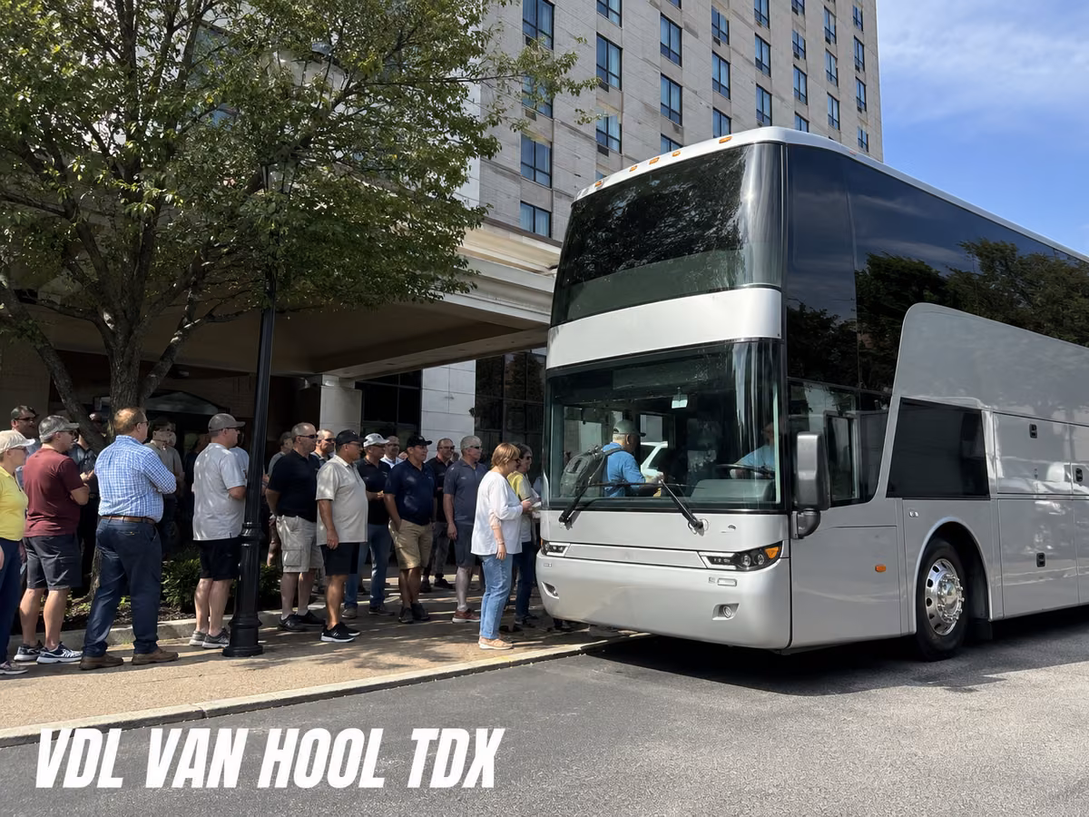 Van Hool double-deck coach with passengers waiting alongside