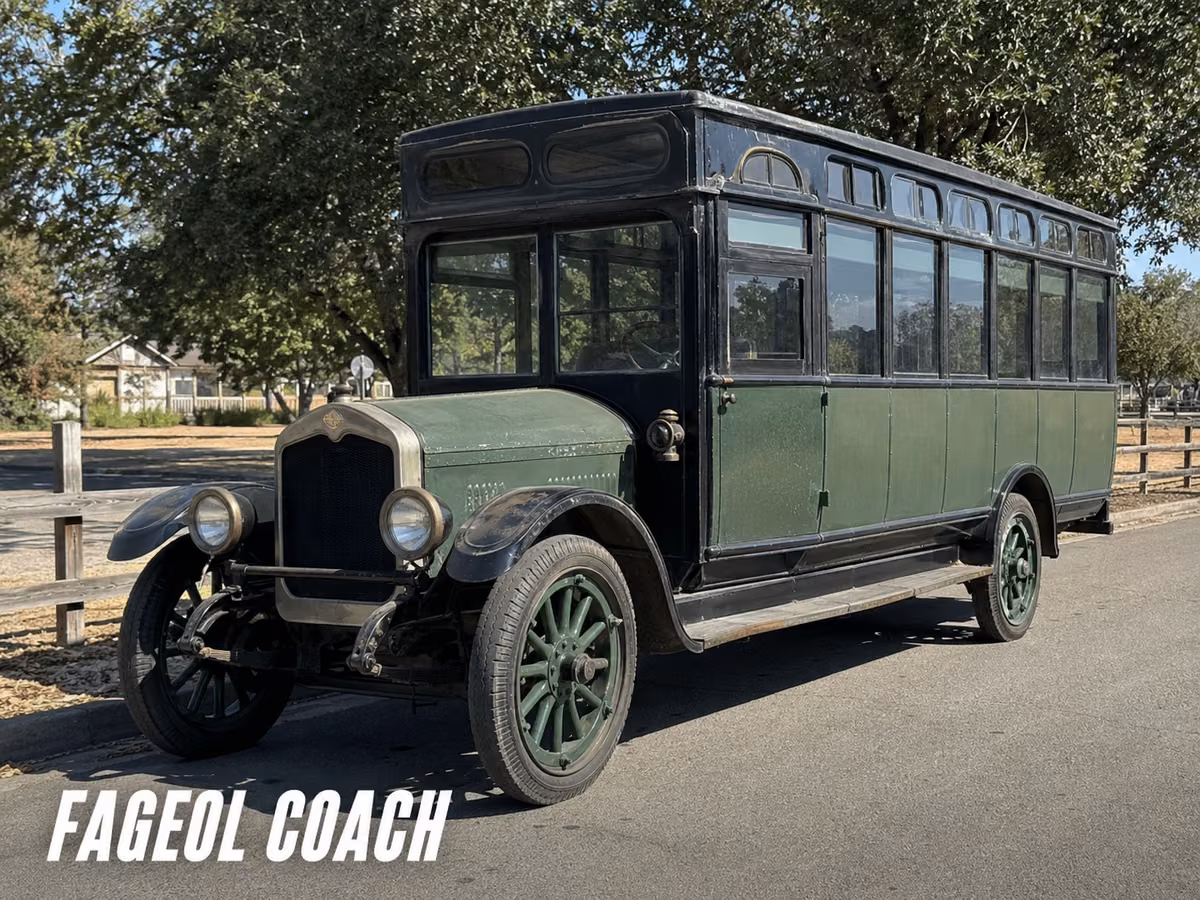 A vintage green Fageol coach with a long enclosed body parked on a street