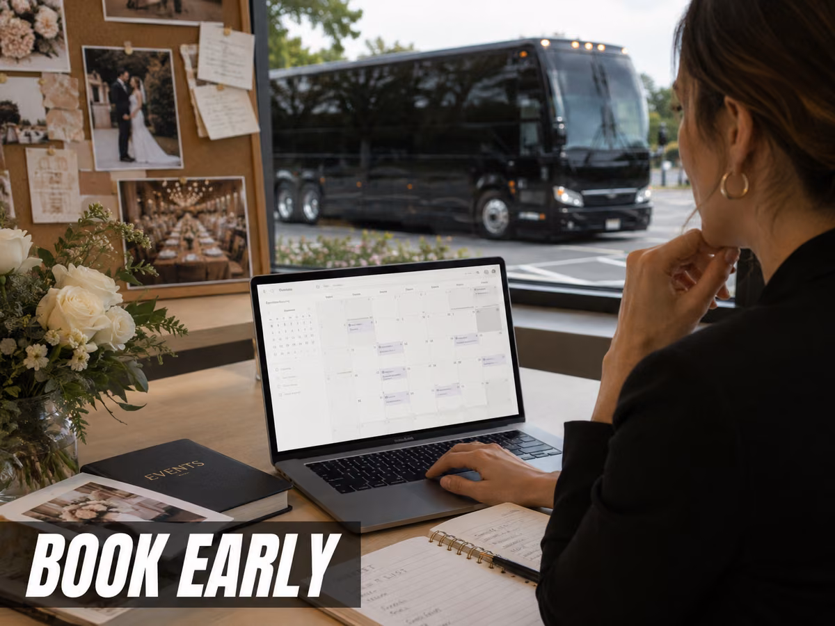 A woman working at a laptop with a calendar open as a bus passes the window behind her.