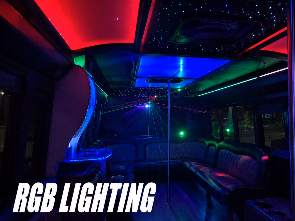 Party bus interior lit with red, blue, and green color-changing LED lighting along the ceiling and walls