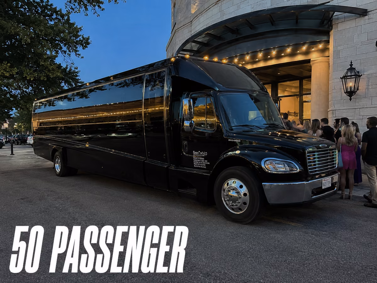 Large black party bus parked outside a venue entrance