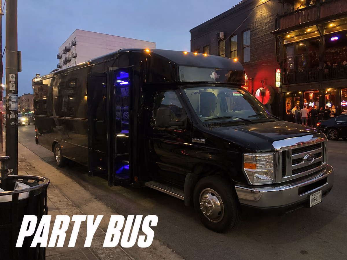 Black party bus parked on a city street at night