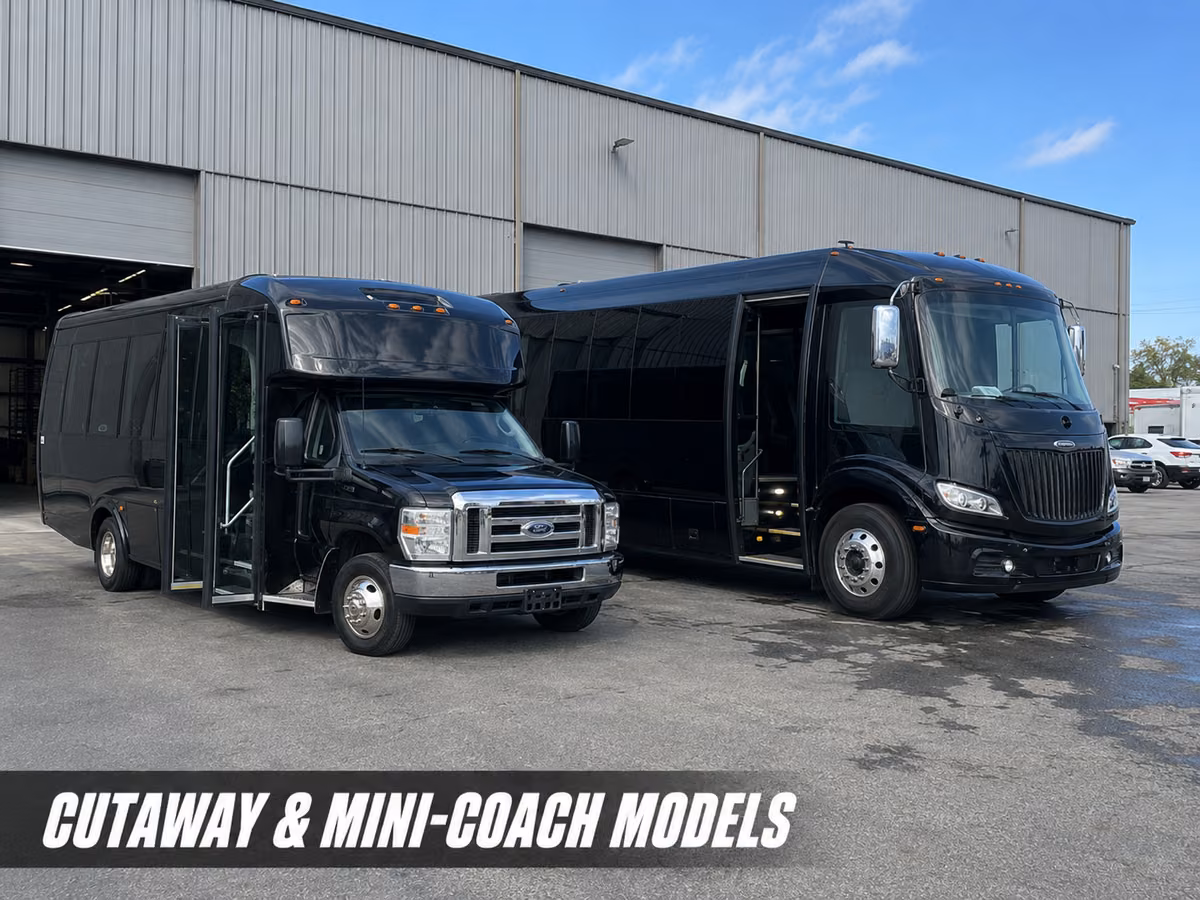 A black cutaway mini-coach bus on a Ford chassis parked beside a metal warehouse