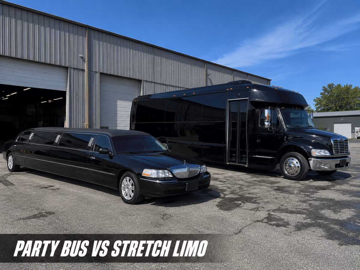 A black stretch limousine parked next to a black cutaway party bus outside a warehouse