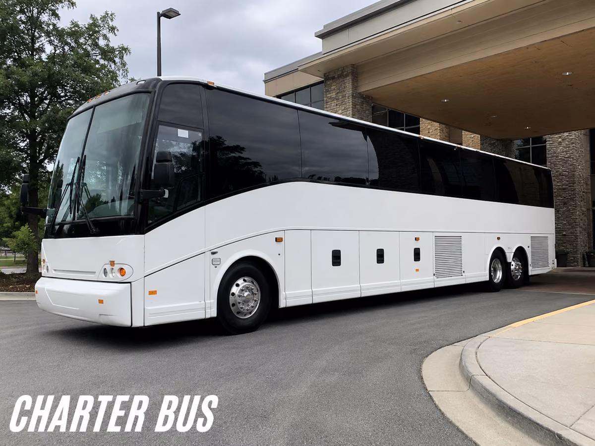 White charter motorcoach parked on a curved driveway outside a hotel