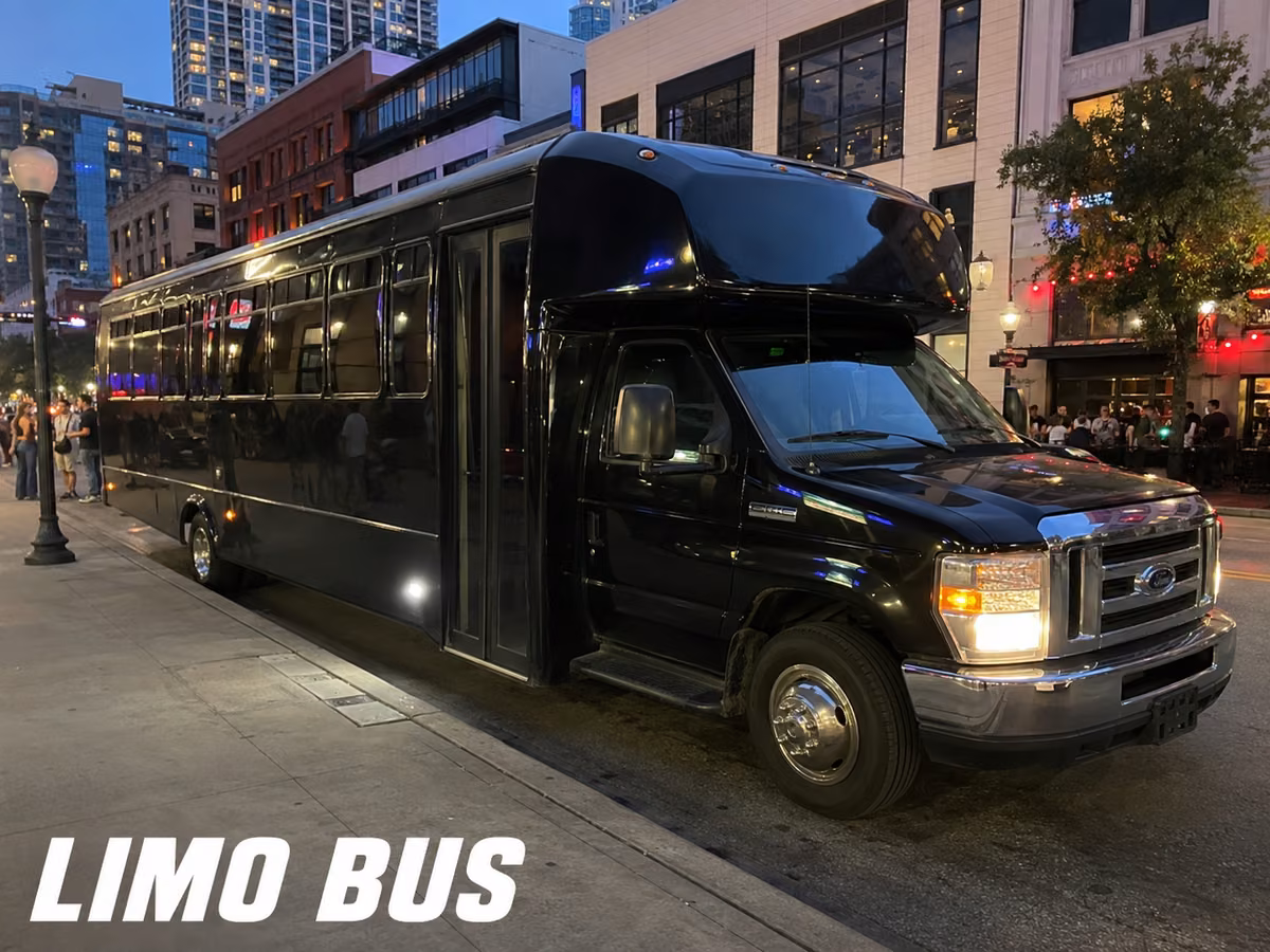 Black limousine-style party bus parked on a city street in the evening