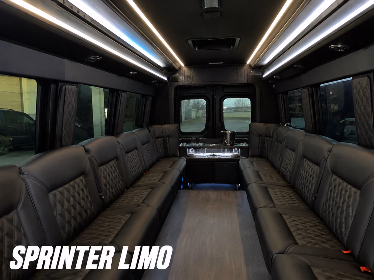 Interior of a Sprinter limousine conversion with black leather lounge seating running along both side walls and accent lighting overhead.